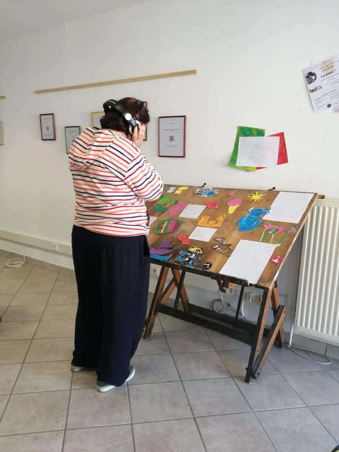 Une visiteuse, casque sur les oreilles, devant une table d’exposition