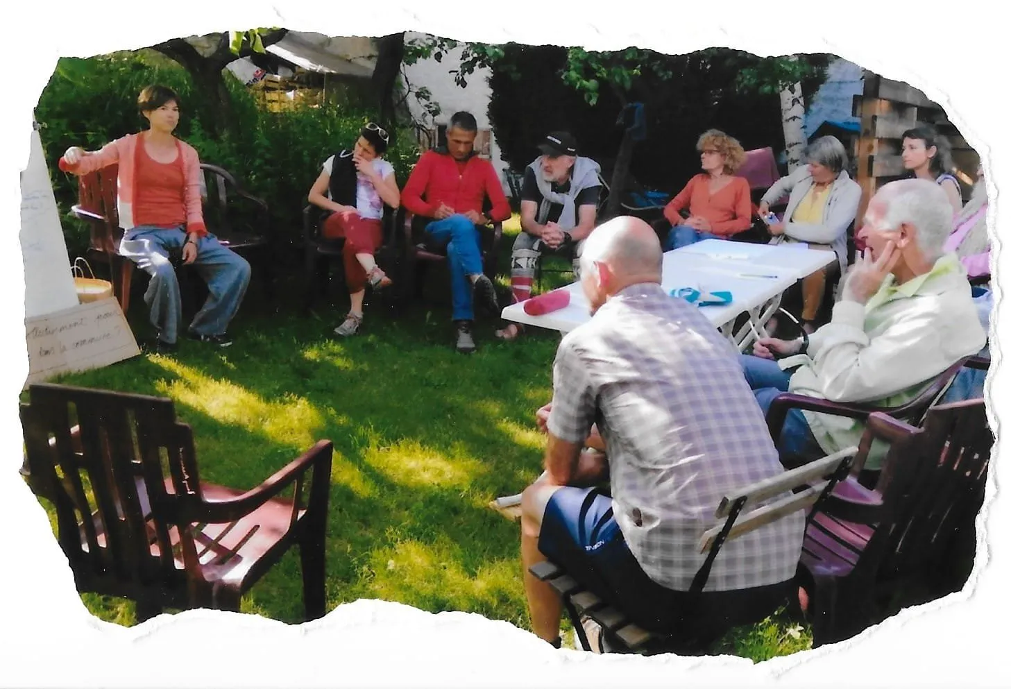 Un groupe assis en cercle dans un jardin, pendant une rencontre