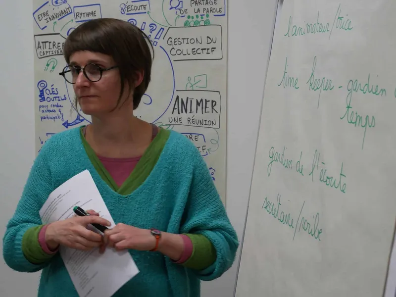 Une animatrice debout devant des affiches de travail