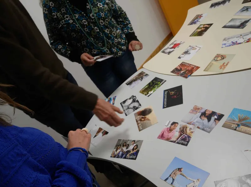 Des mains choisissent des photos étalées sur une table